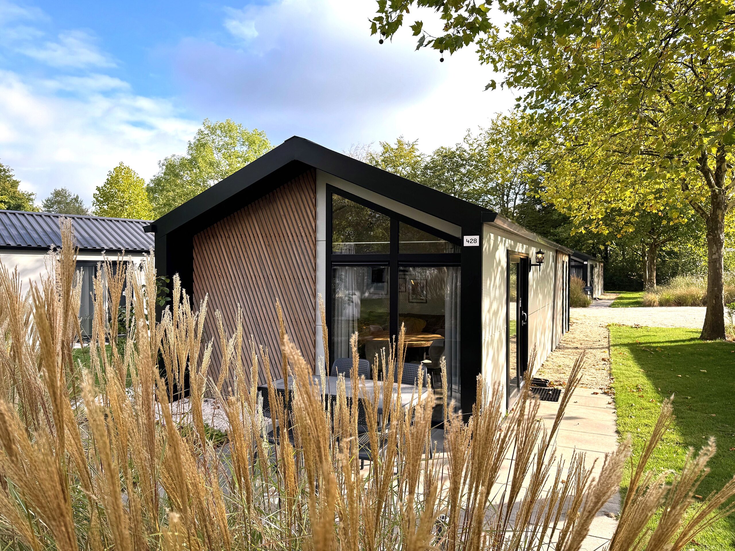 Type Berkel 4p Kavel 428 EuroParcs Kaatsheuvel vakantiehuis voorzijde huis achterzijde huis achtertuin terras tuinmeubilair loungehoek tuinset groen bomen grasveld struiken bloemen tuinpad waterpartij vijver fontein park wandelpad fietspad speeltuin glijbaan schommel zandbak voetbalveld basketbalveld rust stilte natuur omgeving voorzieningen attracties bos meer rivier beek picknickplaats gezellig ontspanning ontdekking natuurlijk wildlife vogels konijnen eekhoorns flora fauna groene omgeving recreatie wandelen fietsen paardrijden wandelroutes fietsroutes uitzicht zonnig schaduw buitenruimte buitenleven buitenactiviteiten gezinsvriendelijk familievriendelijk kindvriendelijk activiteit speelveld sportveld waterloop natuurschoon rustige omgeving parkeren ingang pad bruggetje bordjes natuurgebied bosrijke omgeving gezellig dorp nabijheid winkels nabijheid restaurants lokale attracties themapark nabij museum nabij cultureel historisch ontspanningsplek zitbank schaduwplek boomrijke omgeving bloemenperk grasveld open activiteiten recreatiegebied evenementen festivals seizoensgebonden natuur herfstbladeren lente bloemen zomerzon winterlandschap